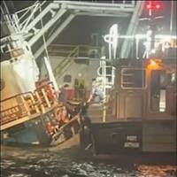 Four crewmen aboard the Sea Cypress, a 71-foot tugboat, prepare to disembark the sinking vessel and climb aboard a Sabine Pilot boat at the mouth of the Sabine Pass Ship Channel in Texas, March 31, 2023. Two of the tugboat’s crew used a handheld torch to cut a hole in the partially submerged vessel’s bulkhead and free the two crewmen trapped in the galley. (U.S. Coast Guard photo)