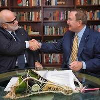 Manfredi Lefebvre D’Ovidio (left) shakes hands with Richard D. Fain after signing a deal that gives Royal Caribbean a 66.7 percent stake in Silversea (Photo: Silversea Cruises)