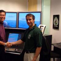 Mark Broster of ECDIS Ltd shaking hands with LTC Terence Ho of the Republic of Singapore Navy. Photo courtesy ECDIS 