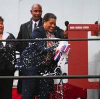 Myrlie Evers-Wilson, the widow of slain civil rights leader Medgar Evers and ship sponsor of Military Sealift Command dry cargo/ammunition ship USNS Medgar Evers, breaks the traditional bottle of champagne against the ship's hull during the ship's christening ceremony Nov. 12 at the General Dynamics NASSCO Shipyard in San Diego. Photo used with permission by Charlie Neuman, San Diego Union Tribune.