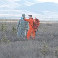 A Canadian search-and-rescue technician points out the causality collection point to a soldier role-playing a wounded crash victim at Donnelly Training Area, Alaska, Oct. 30, 2013. The soldier is part of a Joint Task Force Alaska, Alaska National Guard, U.S. Army Alaska, Canadian Joint Operations Command arctic search-and-rescue exercise at Fort Greeley and Joint Base Elmendorf-Richardson, Alaska. U.S. Army photo