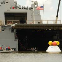 NASA engineers, Navy divers and Sailors assigned to the amphibious transport dock ship USS Arlington (LPD 24) tow a test Orion capsule into the well deck of Arlington. This phase one test determined the best method for recovering the capsule after earth reentry and splashdown in the ocean. (U.S. Navy photo by Chief Mass Communication Specialist James Davis/Released)