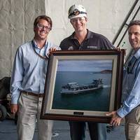 NASSCO Program Manager William McKay and Area Manager Aaron Rockwell present the ship's captain, Jonathan Olmsted, with a photo of the MLP 3 AFSB, USNS Lewis B. Puller. (Photo: NASSCO)