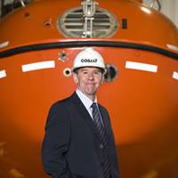 New Cosalt Offshore General Manager Colin Cunningham with a lifeboat supplied by the company. Photo courtesy Think PR ( Scotland) Ltd