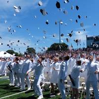 Graduates from USMMA celebrate graduation by tossing covers into the air. The class of 2014 from USMMA included 225 new Merchant Marine and Military Officers. (U.S. Navy photo)