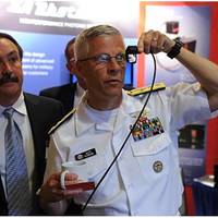 Rear Adm. Matthew Klunder, chief of naval research, tries out a low cost augmented reality head mounted display with SA Photonics general manager, Michael Browne, while touring the exhibit hall at the 2014 Navy Opportunity Forum. The forum is designed to facilitate interaction between small business and members of the acquisition community, lead system integrators, and first and second tier suppliers. (U.S. Navy photo by John F. Williams)