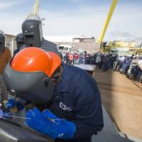Roderick P. Funches, a structural welder at Ingalls Shipbuilding, welds the initials of Julie Sheehan on a ceremonial keel plate that will be welded to WMSL 755, the National Security Cutter named in honor of her great uncle, Douglas A. Munro. Photo by Andrew Young/HII
