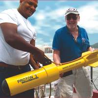 Russell Bennett (r) prepares to survey for shipwreck sites in Panama’s old harbor area with his JW Fishers Proton magnetometer. Presidential Palace is visible in the background between the two men.