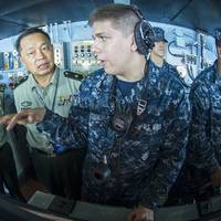 Seaman Alex Snyder, right, explains the functions of the helm on the navigation bridge of the aircraft carrier USS George Washington to Maj. Gen. Chen Weizhan, deputy commander of the People's Liberation Army, Hong Kong Garrison, center, and Col. Li Jiandang, Hong Kong Garrison liaison officer during a distinguished visitor embark. (U.S. Navy photo by Ricardo R. Guzman)