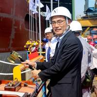 Takaaki Anraku, President Kokusai Cable Ship Company Ltd of Japan, cutting the rope to break the milk pot against the vesselâs hull. Photo: Colombo Dockyard PLC