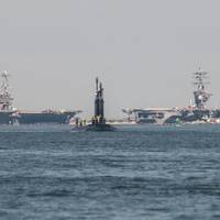 The Delaware SSN 791: The submarine Delaware returns to the Newport News Shipbuilding division following its first set of sea trials with three HII-built aircraft carriers visible in the distance at Norfolk Naval Station. Photo by Ashley Cowan/HII
