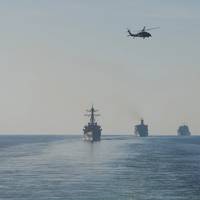 The guided-missile destroyer USS Mitscher (DDG 57), left, the dry cargo and ammunition ship USNS Charles Drew (T-AKE 10), the fleet replenishment oiler USNS Guadalupe (T-AO 300), and the guided-missile cruiser USS Mobile Bay (CG 53) transit the Strait of Hormuz, Dec. 21, 2018. The John C. Stennis Carrier Strike Group is deployed to the U.S. 5th Fleet area of operations in support of naval operations to ensure maritime stability and security in the Central Region, connecting the Mediterranean and