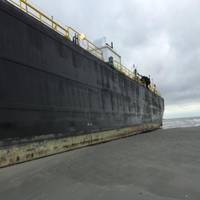 The tugboat, Peter F Gellatly and barge, Double Skin 504, sit grounded near East Beach after high winds pushed it from Bolivar Roads Anchorage, Sunday, Oct. 25, 2015. (U.S. Coast Guard photo by Lt. j.g. In Choi)