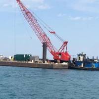 The vessel Kimberly Selvick (left), connected to a crane barge, is pushed by a tug through Lake Michigan after being salvaged from the shores of Lake Michigan near Burnham Park outside of Chicago, May 10, 2014. The Kimberly Selvick became partially submerged after taking on water May 5. (U.S. Coast Guard photo by Lt. Heidi Braglone)