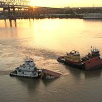 Three tugs hold up a barge that was split in two on the Mississippi, July 23, 2008. At about 2 a.m. that day the 600-foot tanker Tintomara and the Mel Oliver tug and barge collided and approximately 400,000 gallons of number six fuel oil spilled from the barge. (Photo: Chris Lippert / U.S. Coast Guard)