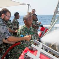 Timor-Leste Defense Force (F-FDTL) members try out HMAS Diamantina's firing fighting equipment during the Minehunter's visit to Timor Leste. (Photo: Ben Catterall)