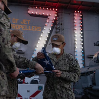 U.S. Sailors fold the American flag after evening colors on the flight deck of the aircraft carrier USS Theodore Roosevelt (CVN 71) April 24, 2020. (U.S. Navy photo by Kaylianna Genier)