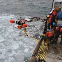 USCG crewmembers used an oil-skimming device to recover peat moss, acting as a substitute for spilled oil, near Mackinac Island.