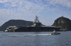 Tugboats prepare to maneuver the U.S. Navy’s only forward-deployed aircraft carrier USS Ronald Reagan (CVN 76) to port in Busan, Republic of Korea, Sept. 23. (Photo: Leon Wong / U.S. Navy)