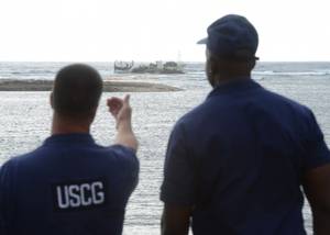 U.S. Coast Guard personnel discuss future operations for the removal of product aboard the commercial fishing vessel Chui Zai Fa No. 1 grounded about 300-yards off Leone Bay (U.S. Coast Guard photo by Tara Molle)