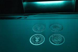 Logos from Newport News Shipbuilding and 3D Systems were fabricated during a demonstration of the new 3-D printer. (Photo by John Whalen/HII)