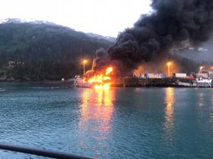 A fire burns at Delong Dock after an explosion on fixed barge in Whittier, Alaska, July 8, 2019. In addition to Coast Guard crews, response efforts included members of the Whittier Fire Department, Whittier Police Department, Anton Anderson Memorial Tunnel Fire Department and Girdwood Fire Department. Photo courtesy of Coast Guard Sector Anchorage.
