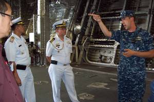 Cmdr. Dave Back (right), executive officer of USS Independence (LCS 2) Gold Crew, conducts a tour of his ship to attendees of the Sea Giraffe Users Group at Naval Base San Diego.  He is seen here showing the ship’s spacious mission bay to Cam Fung from Canada (left), and Capt. Charlie Songsawangthus and Cmdr. Sarawoot Chiyangcabut from Thailand. (Photo by Papola Kani, Consulate of Sweden, San Diego)