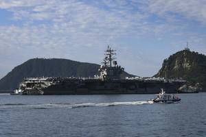 Tugboats prepare to maneuver the U.S. Navy’s only forward-deployed aircraft carrier USS Ronald Reagan (CVN 76) to port in Busan, Republic of Korea, Sept. 23. (Photo: Leon Wong / U.S. Navy)