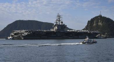 Tugboats prepare to maneuver the U.S. Navy’s only 