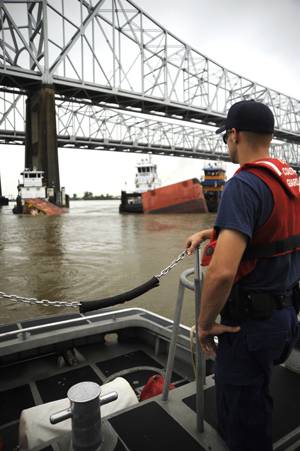 A Coast Guard crewmember aboard a 41-ft. smallboat from Coast Guard Station New Orleans overlooks the sunken barge in the Mississippi River in downtown New Orleans after the motor vessel Tintomara and a tub and barge collided early Wed. July 23, 2008 spilling approximately 419,000 gals. of number six fuel oil.  (U. S. Coast Guard photo/Petty Officer 2nd Class Thomas M. Blue)