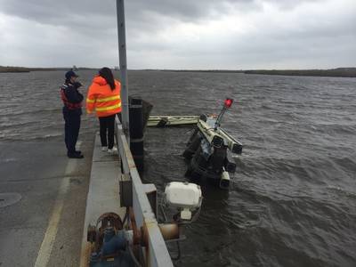 A Coast Guardsman from the Marine Safety Unit Port Arthur stands at the edge of Black Bayou Bridge observing a damaged fender after it was hit by a boat that lost steering March 7, 2016. (U.S. Coast Guard photo by Jennifer Andrew)