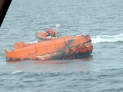 A crew from the Coast Guard Cutter Shearwater approaches a capsized lifeboat from the Bow Mariner. U.S. COAST GUARD PHOTO