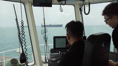 A PSA Marine Tug Master and Thomas monitoring how the smart navigation system maneuvers the harbor tug during sea trials. (Photo: Wärtsilä)