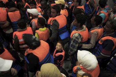 A young boy surrounded by adults after being rescued in June 2014 from a boat on the Mediterranean Sea. Photo: UNHCR/A. D’Amato