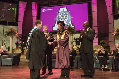 (From left) The Apprentice School Director Everett Jordan presented the school’s 10,000th graduate, Sara Ruggles, with a plaque to commemorate the milestone as Newport News Shipbuilding President Matt Mulherin and Newport News Shipbuilding Vice President of Trade Operations Ray Bagley joined other shipyard leadership in applause. Photo by John Whalen/HII