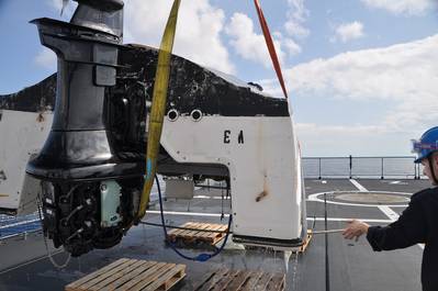 A capsized vessel is lifted onboard the Royal Netherlands Navy Zeeland 75 miles northeast of West Palm Beach, Fla., Feb. 6, 2014. The crew aboard the Zeeland discovered and rescued seven people and recovered three bodies. (USCG photo)