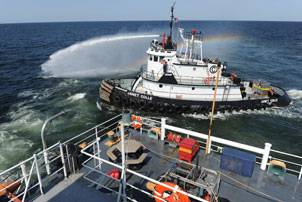 Commercial tugboat Janet Colle pressure washes the exterior of USCGC Harry Claiborne (WLM 561) of residual oil after an oil clean up mission. Claiborne is equipped with a Vessel of Opportunity Skimming System (VOSS) to help remove oil from the ocean surface. (U.S. Navy photo by Mass Communication Specialist 2nd Class (AW/SW) Jonathen E. Davis)