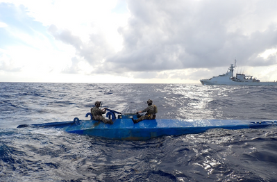 Crew members form U.S. Coast Guard Tactical Law Enforcement Detachment (LEDET) 111 and British Royal Navy team embarked aboard HMS Trent (P244) interdicts a semi-submersible drug smuggling vessel in the international waters of the Caribbean Sea, Aug. 26, 2024. Three suspected smugglers and 1,239 pounds of illegal narcotics from this interdiction were transferred to federal custody for prosecution by the U.S. Department of Justice. (Courtesy image from United Kingdom Royal Navy)