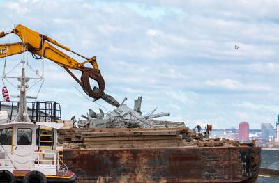 Debris removed from the Patapsco River is loaded onto a barge for removal by response personnel. The Unified Command is working to restore flow of critical commerce in and out of Baltimore. (Key Bridge Response 2024 Unified Command photo by Dylan Burnell, USACE.)