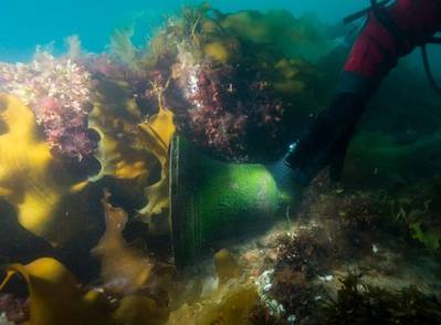 The detached ship’s bell of HMS Erebus as found on the deck next to the windlass. Note the embossed ‘broad arrow’ British government property mark, and the embossed date 1845. (© Parks Canada / Thierry Boyer)
