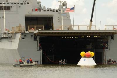 NASA engineers, Navy divers and Sailors assigned to the amphibious transport dock ship USS Arlington (LPD 24) tow a test Orion capsule into the well deck of Arlington. This phase one test determined the best method for recovering the capsule after earth reentry and splashdown in the ocean. (U.S. Navy photo by Chief Mass Communication Specialist James Davis/Released)