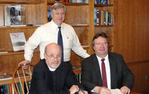 Eric Larsson (standing), Director of Maritime Education, and SCI’s President & Executive Director, the Rev. David M. Rider (L), sign the contract for the first phase of SCI’s Houston simulator upgrades with Kongsberg Maritime, represented by Area Sales Manager Henry Tremblay (R).