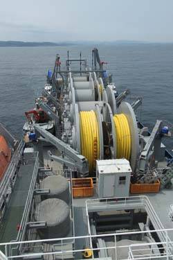 Offshore petroleum distribution system ship MV Vice Adm. K.R. Wheeler deploys yellow, flexible pipe to the seabed off the coast of Pohang, Republic of Korea, June 23. (U.S. Navy photo by Ed Baxter, Sealift Logistics Command Far East) 