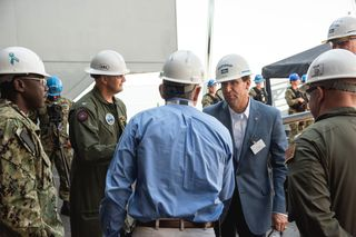 HII President and CEO Mike Petters (center) greets Secretary of Defense Mark Esper during his first visit to the company’s Newport News Shipbuilding division and the aircraft carrier USS Gerald R. Ford (CVN 78). Photo by Matt Hildreth/HII