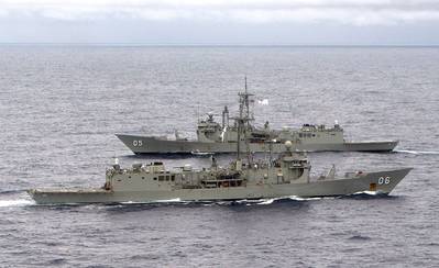 HMAS Newcastle and HMAS Melbourne pass each other as Melbourne takes over from Newcastle as the Australian ship assigned to Operation SLIPPER. (Credit: LA Richard Close)