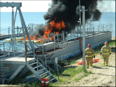 In-situ test burn in progress with members of the fire safety team, Mike Hering and MK1 Darrel Boyles, on watch. September 19, 2018, on Little Sand Island (Photo: Coast Guard Auxiliarist Sarah Canatsey)