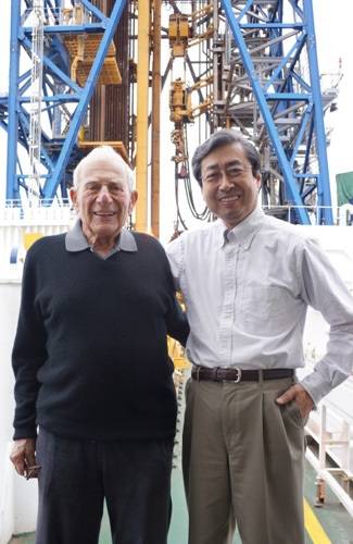 JAMSTEC President Asahiko Taira with Walter Munk on the deck of D/V Chikyu in front of the ship's drilling derrick. Credit: JAMSTEC