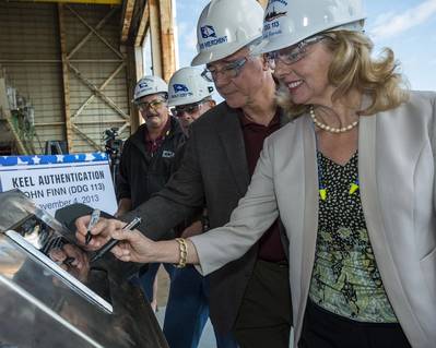 Laura Stavridis, the ship's sponsor, (right) and Bob Merchent, Ingalls vice president of U.S. Coast Guard and surface combatant programs, (second from right) mark their initials on the keel plate for the destroyer John Finn (DDG 113). Also pictured are (left to right) George Nungesser, Ingalls’ DDG 51 program manager, and Ingalls Shipbuilding President Irwin F. Edenzon. Photo: Lance Davis
