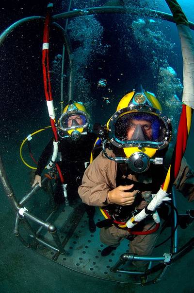 Lt. Cmdr. Bobby Greene, a Naval Reservist assigned to Explosive Ordnance Disposal Operational Support Unit (EODOSU) 7, right, and Chief Equipment Operator Mark Hurley, assigned to Underwater Construction Team (UCT) 2, stand on a stage that will take them back to the surface during a dive supporting Navy Dive Global Fleet Station 2008 off the coast of St. Kitts. (U.S. Navy photo by Senior Chief Mass Communications Specialist Andrew McKaskle)