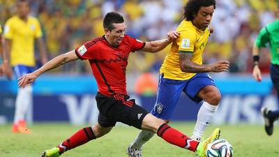 Marcelo of Brazil is challenged by Hector Herrera of Mexico (Photo courtesy of FIFA)